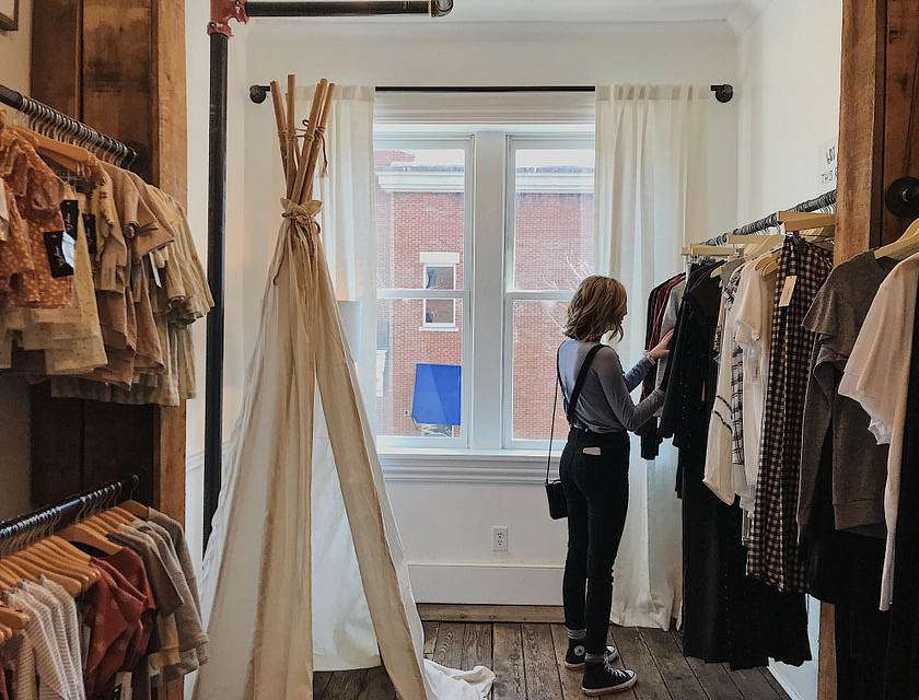 mujer de perfil vestida al estilo vintage en una tienda de ropa vintage