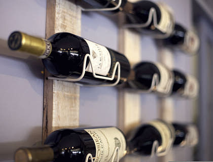 Algunas botellas de vino en un estante de una vinatería.