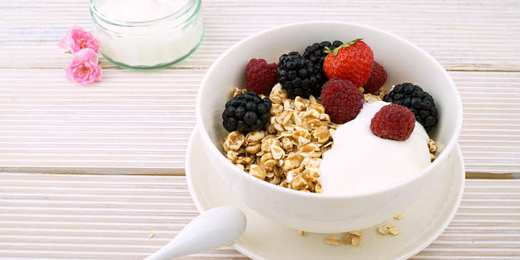 Un plato con yogurt, frutos rojos y granola en una yogurtería.