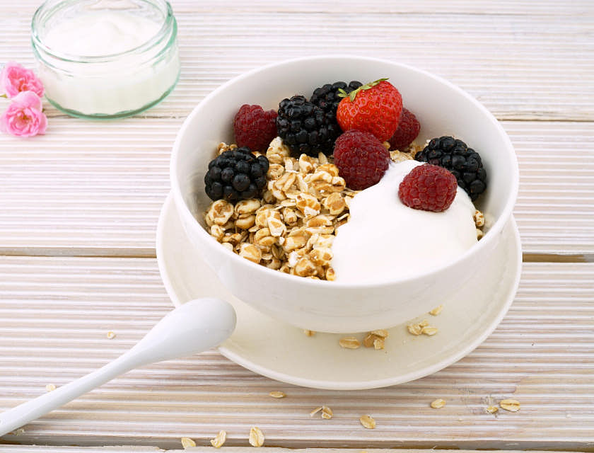 Un plato con yogurt, frutos rojos y granola en una yogurtería