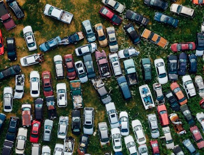 Vista aérea de decenas de vehículos inservibles estacionados en un yonke.