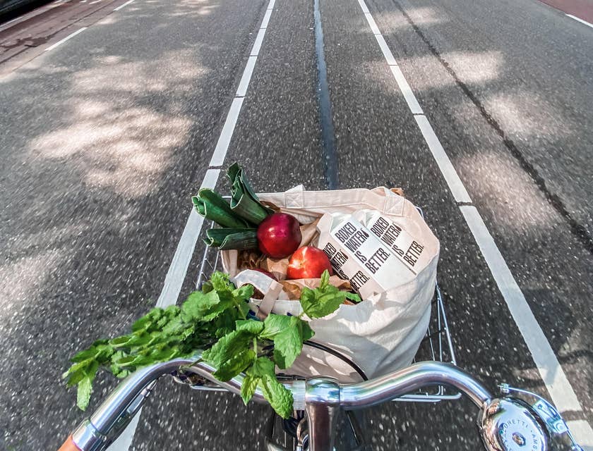 Una canasta de bicicleta llena de comida saludable por parte un negocio con nombre saludable.