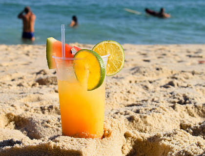 Drink preparado em uma barraca de drink na areia de uma praia.
