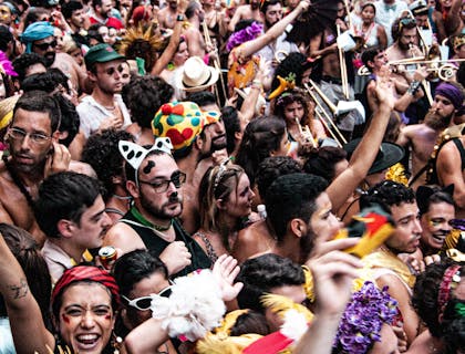 Diversas pessoas fantasiadas em um bloco de carnaval.