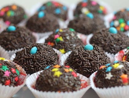 Diversos brigadeiros cobertos com granulados em uma brigaderia