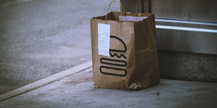 Uma sacola com lanche entregue por um delivery de lanches.