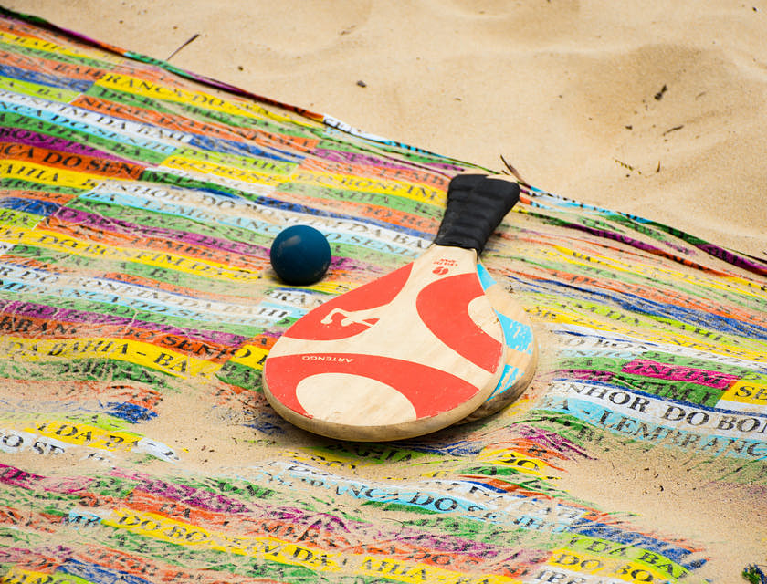 duas raquetes e uma bolinha de frescobol em uma praia
