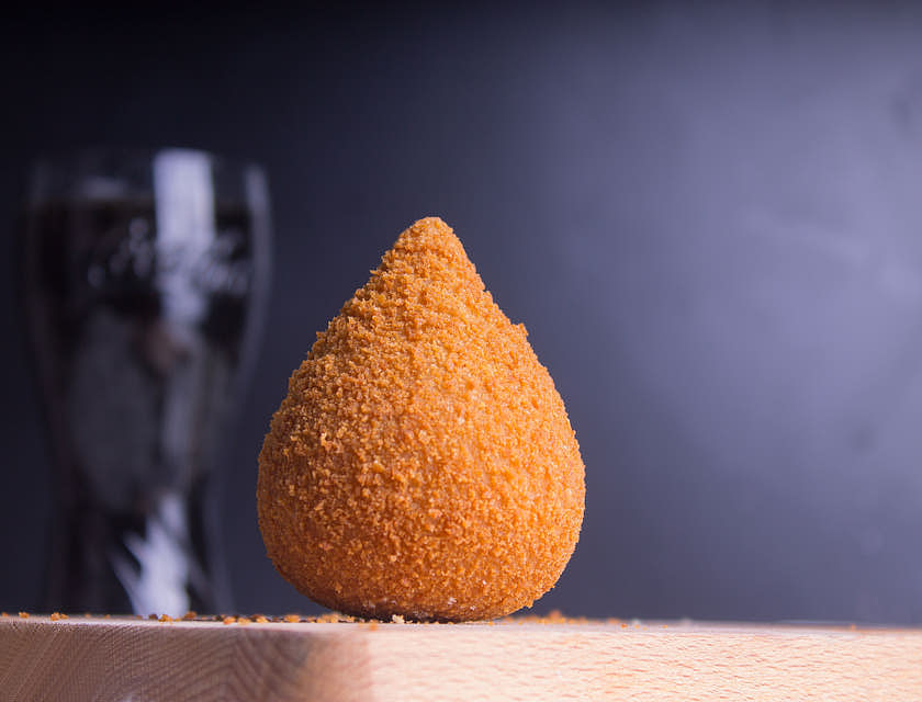 uma coxinha na mesa de uma loja de coxinhas