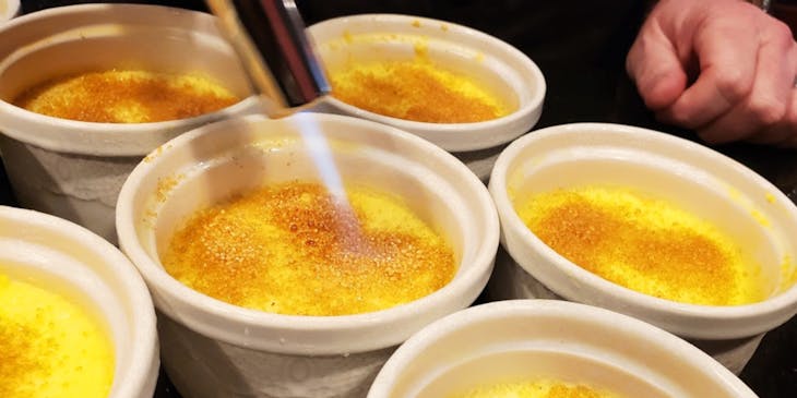 Uma pessoa fazendo quindim brûlée em uma loja de quindim.