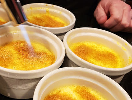 Uma pessoa fazendo quindim brûlée em uma loja de quindim.