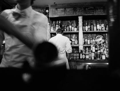 Due baristi che lavorano al bar di un circolo.
