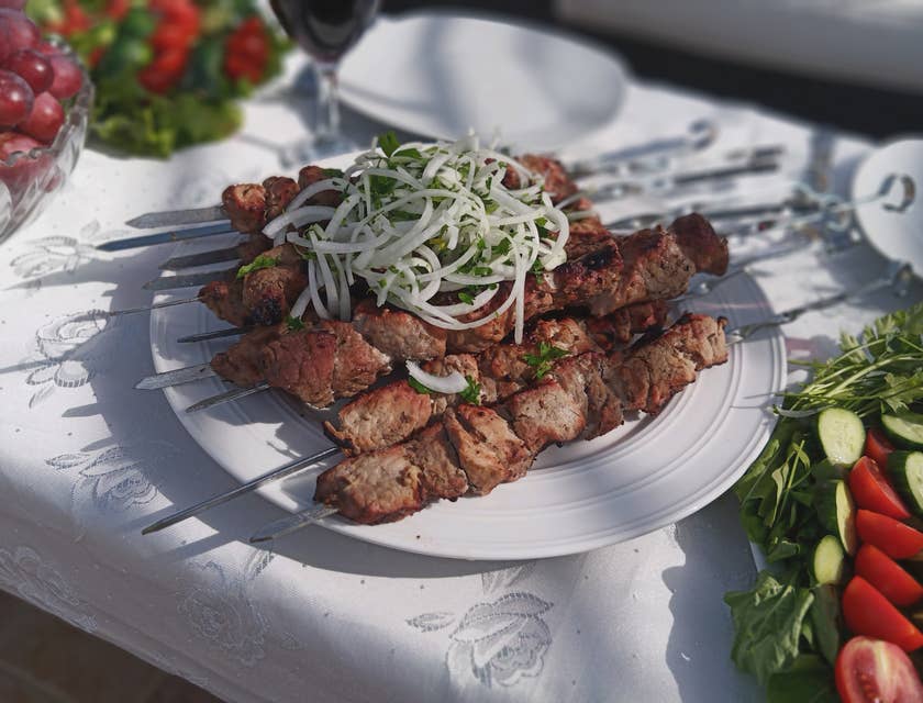 Del kebab servito su un piatto bianco in un ristorante iraniano.