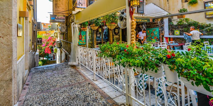 A vibrant Sicilian restaurant decorated with greenery.