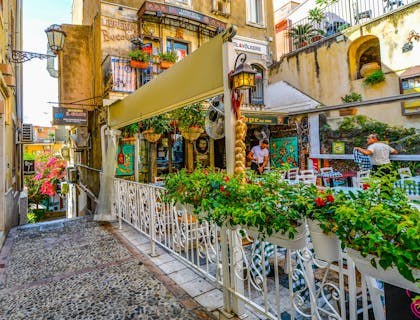 A vibrant Sicilian restaurant decorated with greenery.