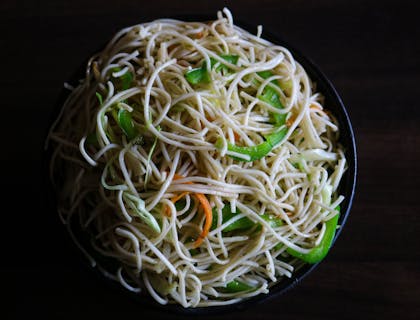 Un bol de nouilles avec poivron vert.