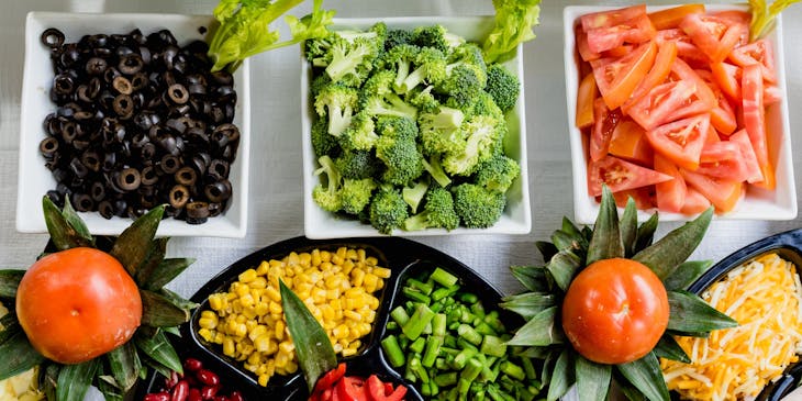 A table full of healthy vegetables and salads at a nutrition business.