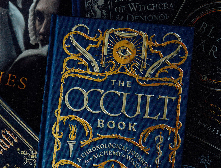 A blue, hard-cover occult book on a dark background.