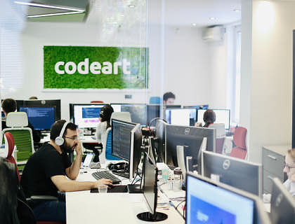 Employés assis à leur bureau portant des écouteurs.