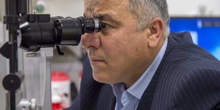 Ophthalmologist using a slit lamp to perform an eye examination.