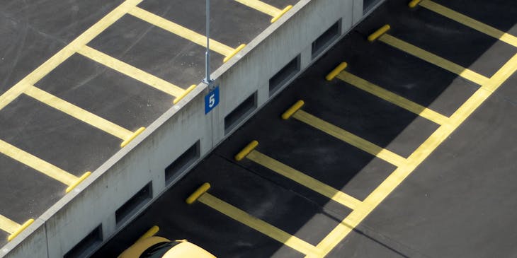 Yellow car in an empty parking lot.