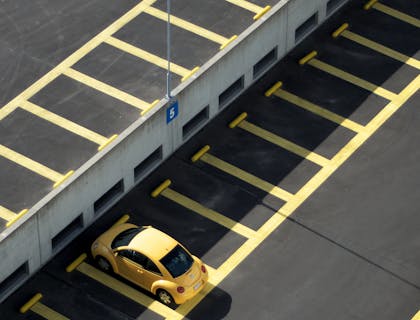 Carro amarillo estacionado en un estacionamiento vacío en una empresa de estacionamiento.