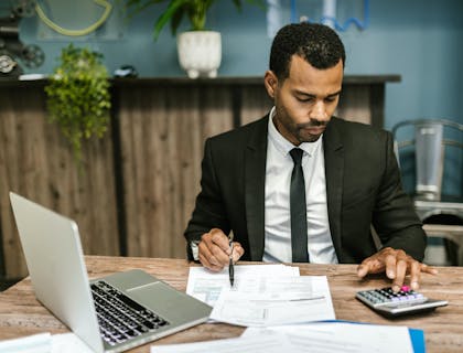 Un contador haciendo cálculos en una oficina de servicios de nómina.