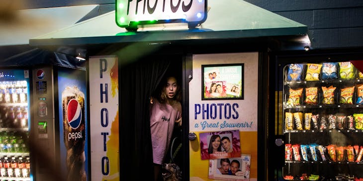 Girl exiting photo booth with her dog.