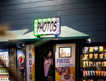 Una chica saliendo de una cabina fotográfica con su perro.