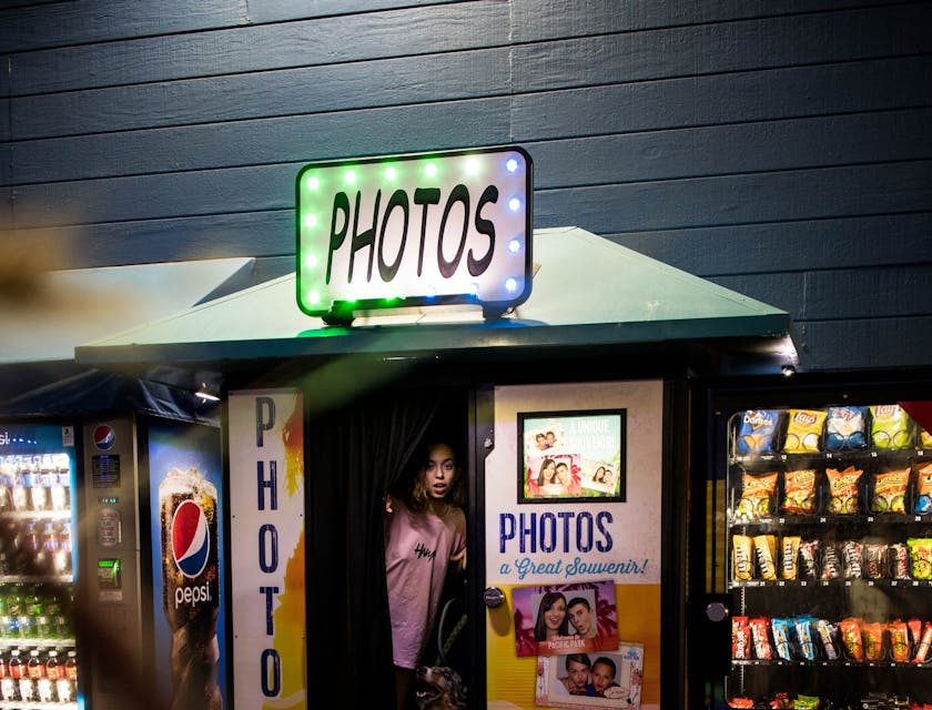 Una ragazza che sta uscendo da un photo booth insieme al suo cane.