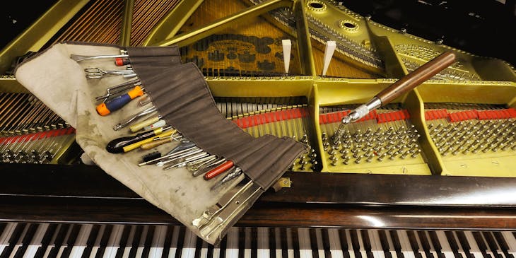 Piano tuning tools lying on a grand piano.