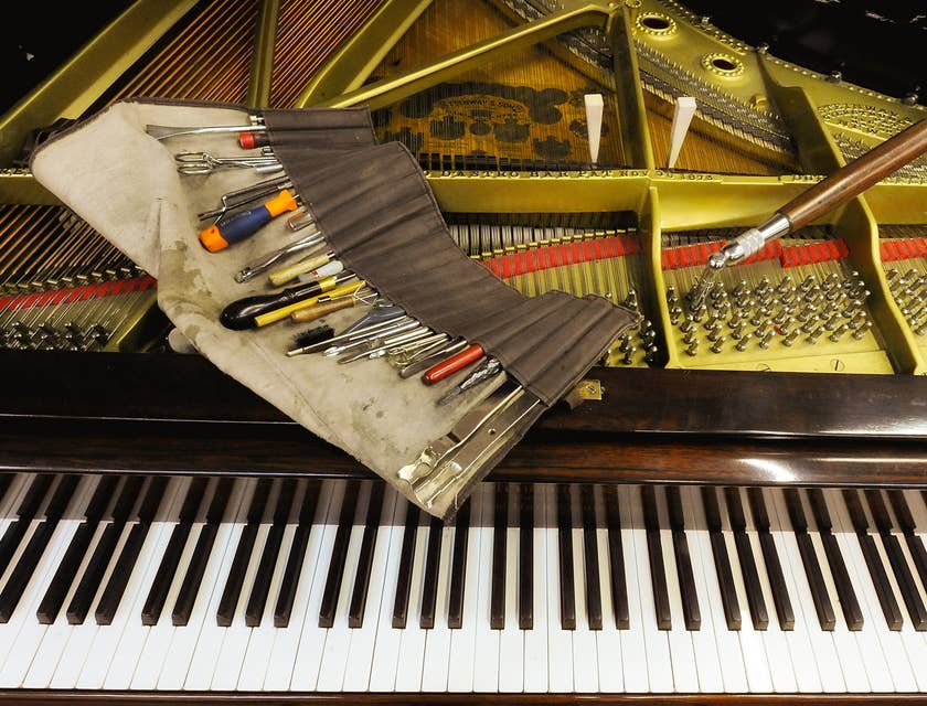 Herramientas posadas sobre un piano de cola en un negocio de afinación de pianos.