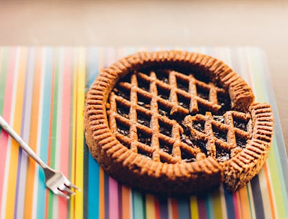 Torta fatiada em um jogo americano colorido com um garfo ao lado.