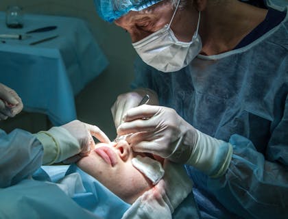 Plastic surgeon performing facial surgery.