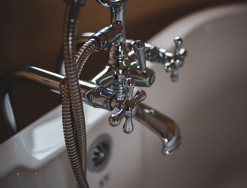 A chrome bathtub faucet installed by a plumbing business.