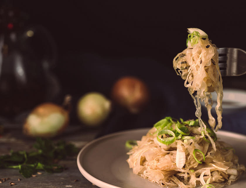 Un restaurant polonais qui sert des pâtes avec de la choucroute sur une assiette en céramique.