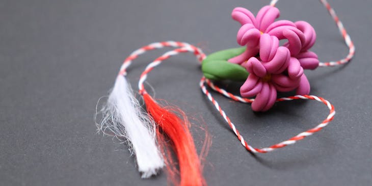Polymer clay flowers on a red and white string.