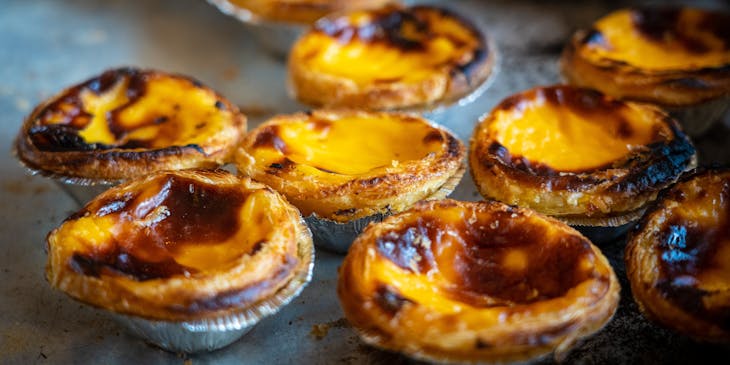 Portuguese custard tartlets on a grey background.