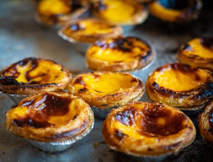 Pequeñas tartas portuguesas sobre un fondo gris en un restaurante portugués.