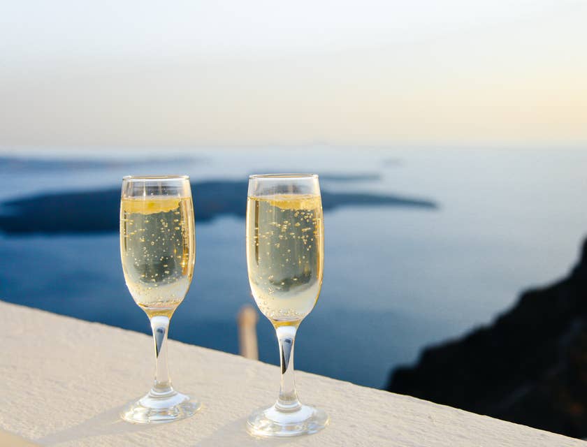 Due bicchieri di raffinato champagne in una terrazza vista mare.