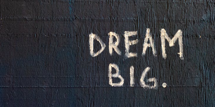 A sign with a positive message that reads "dream big".