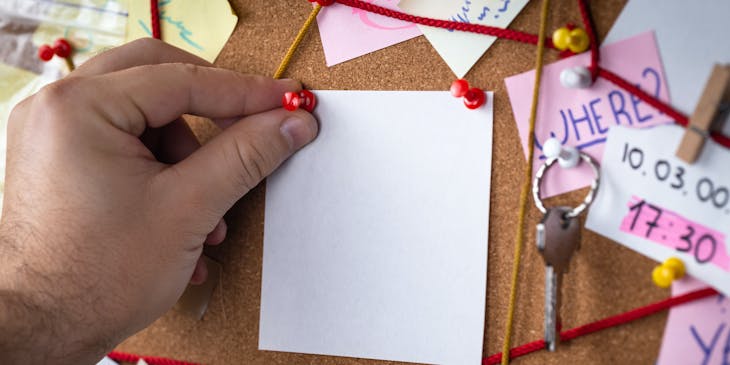 A private investigator placing a pin in a board.
