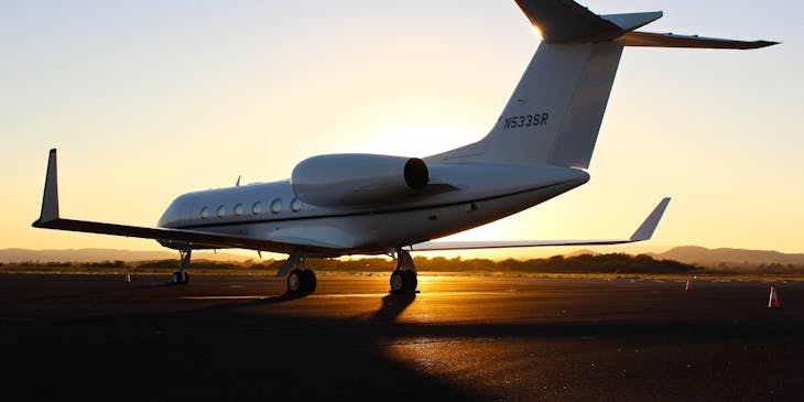 A private jet on a landing strip at an airport.