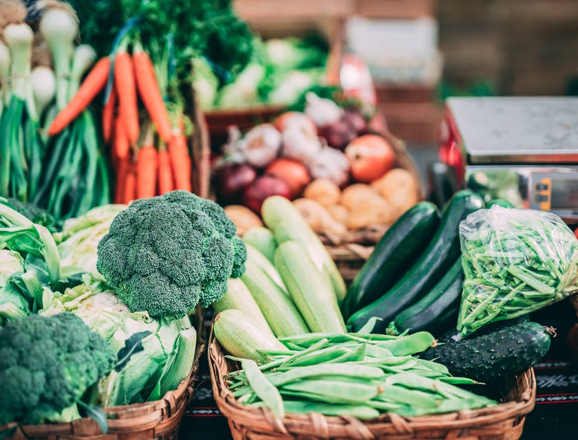 Vegetales y verduras frescas en cestas encima de una mesa de un negocio de producción agrícola.