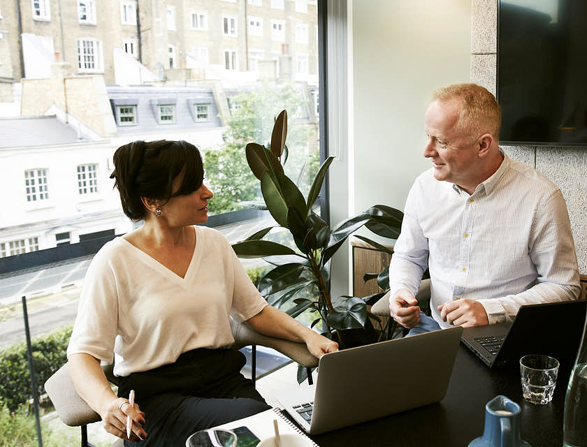 A woman chatting to a man in an office.