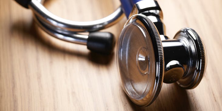 Pulmonologist's stethoscope lying on a brown surface.