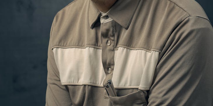 Man posing in a gray shirt.