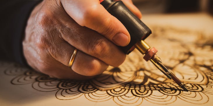Person holding a pyrography pen