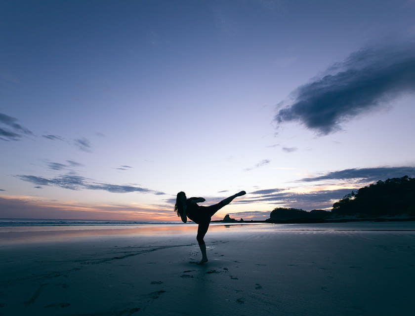 Una mujer practicando qi gong durante el amanecer en un negocio de qi gong.