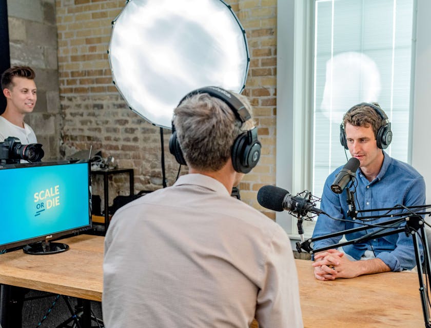 Un intervenant de radio interviewant quelqu'un à l'intérieur d'une station de radio.