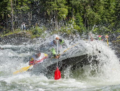 Grupo de personas disfrutando de una aventura de rafting y kayak.
